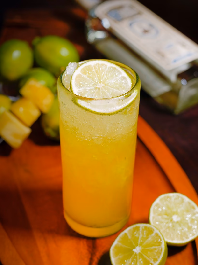 An El Matador Pedro in a tall glass with limes and pineapple